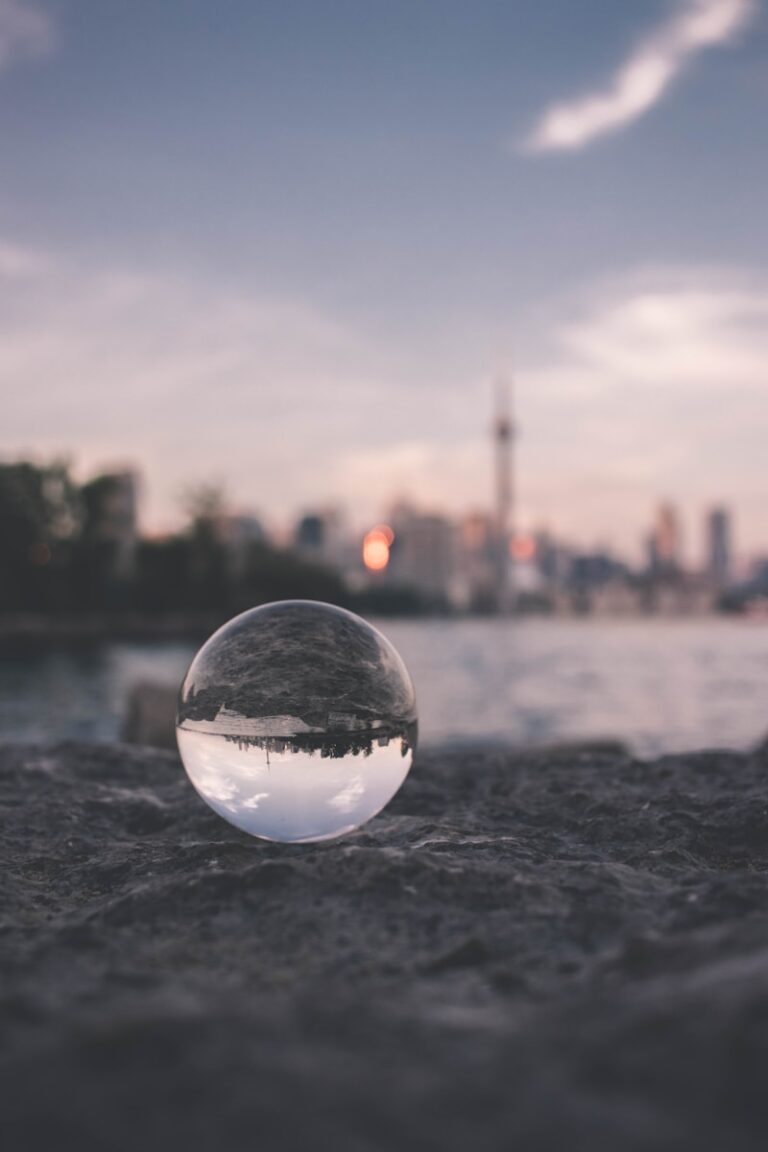 selective focus photography of glass ball on sandy ground