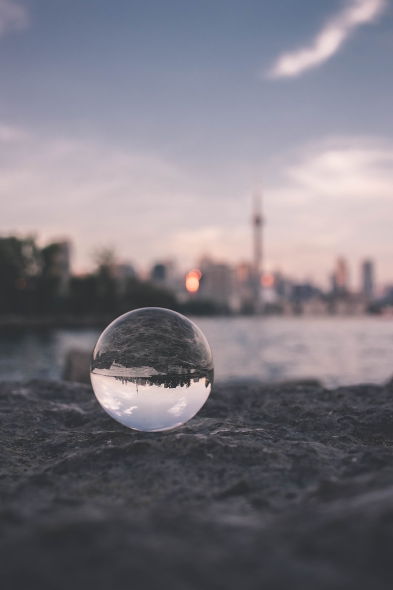 selective focus photography of glass ball on sandy ground